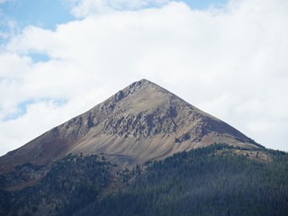 Fototapeta premium Close up of a mountain peak in Loveland Pass, Colorado with green trees at its foot