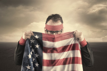 Businessman hiding behind USA flag