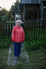 Obraz premium Elderly woman near her house in the village.