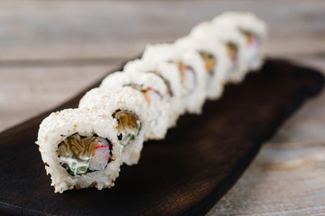 Restaurant menu, Japanese traditional food. Appetizing sushi rolls served on wooden tray