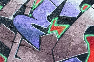 Fragment of graffiti drawings. The old wall decorated with paint stains in the style of street art culture. Colored background texture in purple tones