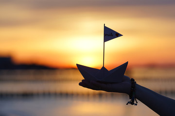 Papierboot in der Hand halten - Sonnenuntergang