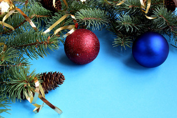 Christmas mood spruce branches and toys on a blue background