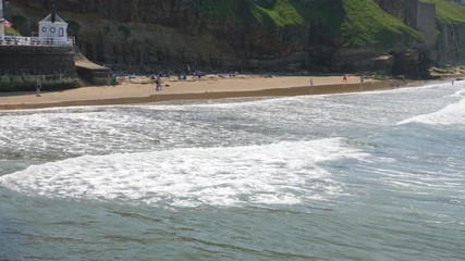 View over the sea of people on Whitby beach, in Summer.