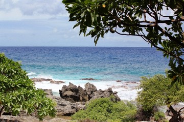 Coastal view of the blue waters and rocky shorelines of Chulu Beach, also known as Star sands beach on Tinian, Northern Mariana Islands.