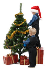 Two little boys with gifts and Christmas tree