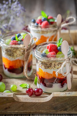 Sweet granola in jar with yoghurt and berry fruits