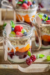 Fresh oat flakes with fresh fruits and yoghurt in jar