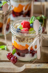 Fresh oat flakes in jar with yoghurt and berry fruits