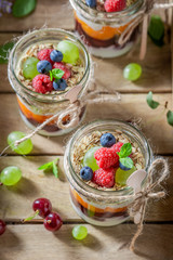 Homemade granola in jar with yoghurt and berry fruits
