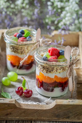 Delicious oat flakes with fresh fruits and yoghurt in jar