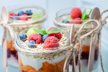 Tasty granola with fresh fruits and yoghurt in jar