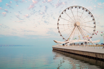 Ferris wheel on waterfront. Big carousel.