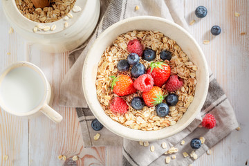 Oat flakes with berry fruits for breakfast on rustic table