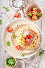 Sweet american pancakes with fresh strawberries and sugar