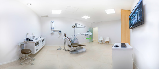 Panorama of a clean white modern dentist cabinet with a dental radiography on a screen. Spacious...