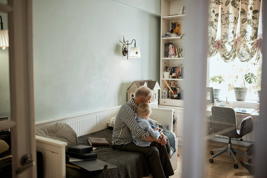 Grandfather and grandson using digital tablet for surfing internet and playing game in living room
