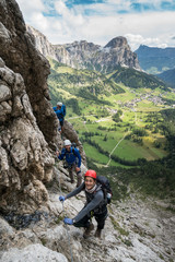 Fototapeta premium three mountain climbers on a Via Ferrata in the Dolomites in Alta Badia