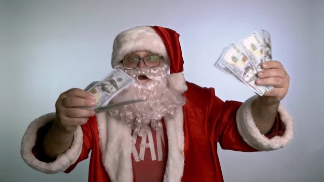 Santa Claus dancing on a white background with money in his hands.
