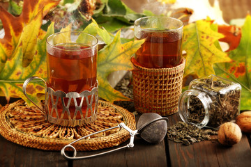 Two glasses of hot tea an autumn day with colorful leaves on wooden vintage background