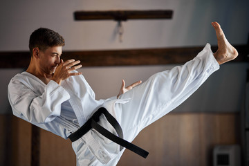 Man in kimono doing karate kick