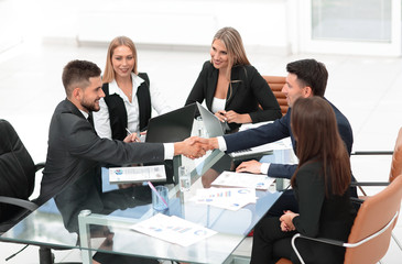 handshake of business partners sitting at your Desk