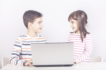 Happy kids using a laptop computer. Education, technology and e-learning concept