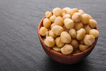 delicious macadamia nuts on a dark stone background