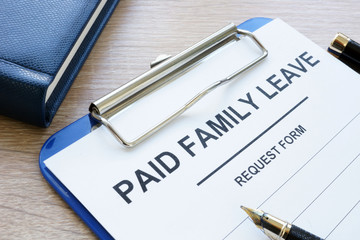 Paid family leave form in clipboard and note pad.