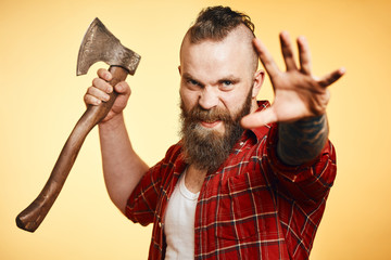 Furious agressive lumberjack. bearded man swinging with axe