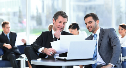 business partners discussing a new project, sitting in the lobby of the office.