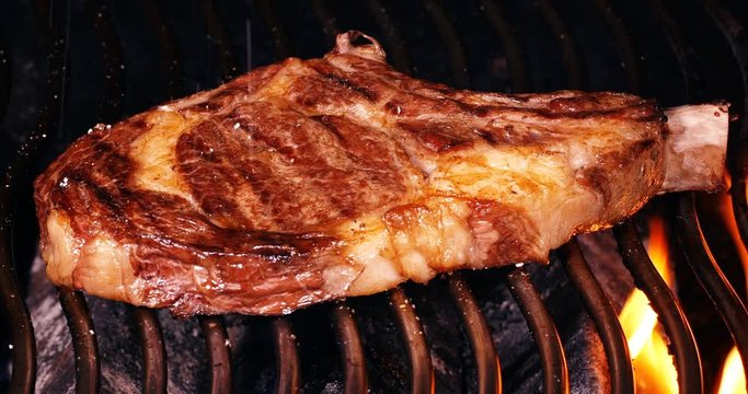 C4K closeup shot of the juicy beef steak on a barbecue grill
