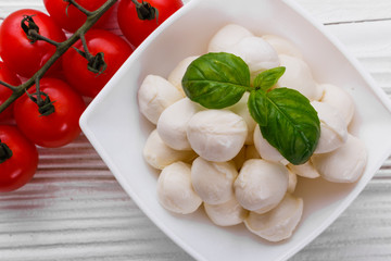 Mozzarella tomatoes and basil on a wooden rustic background