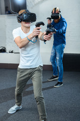 Two young guys are playing in virtual reality glasses