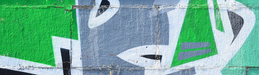 Fragment of graffiti drawings. The old wall decorated with paint stains in the style of street art culture. Colored background texture in green tones