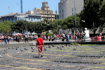 Jeune garçon courant derrière des pigeons sur une place publique