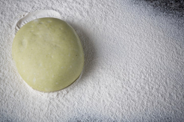 piece of dough for pizza in flour