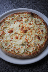 pizza with pear and gargantilla on a white plate