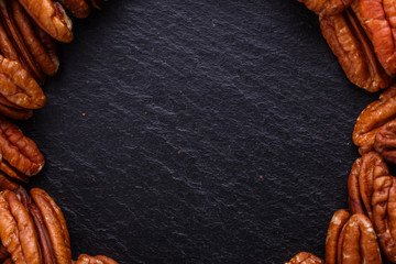 delicious pecan nuts on a dark stone background