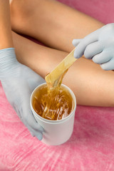 Removing unnecessary hair on the hands. Procedure sugaring in a beauty salon.Depilatory sugar paste