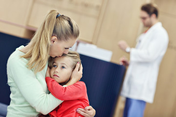Fototapeta premium Little girl is crying while with her mother at a doctor on consultation