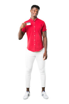 Full body of Young african american man holding a credit card on white background