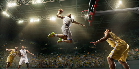 Basketball players on big professional arena during the game. Basketball player makes slum dunk....