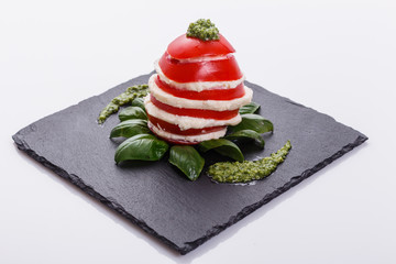 Caprese salad on a white acrylic background