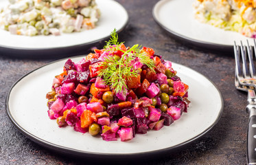 Russian food on dark background. Assortment salad of Russian cuisine - Olivier salad, vinaigrette -...