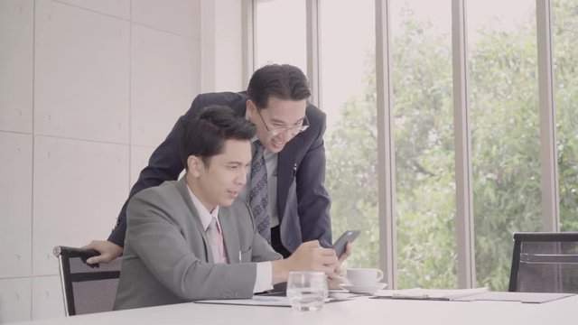 Slow motion - Smart handsome businessmen using smartphone to check stock market data. Male checking stock charts and feeling happy when it uptrend.