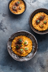Three risotto bowl on stone background, top view