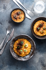 Three risotto bowl on stone background, top view