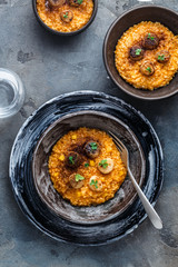 Risotto with scallops in black plates, top view, copy space