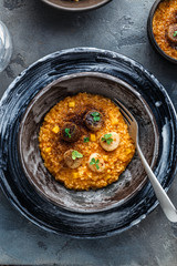 Pumpkin risotto close view, black plate flat lay